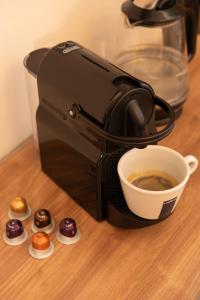una cafetera con una taza de café y donuts en Kazimierz Residence Apartments by Staymoovers, en Cracovia