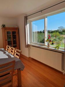 Un comedor con una mesa y un gran ventanal. en Lovely Holiday Home With Views Of Fields, en Lebøl