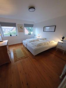 Un dormitorio con una cama grande y dos ventanas. en Lovely Holiday Home With Views Of Fields, en Lebøl 33 fotos más