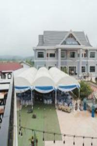 Tulip Hotel في لوانغ نامثا: مبنى كبير مع مظلات زرقاء وبيضاء أمامه