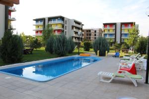 a swimming pool with lounge chairs next to a building at Airport Residence in Otopeni