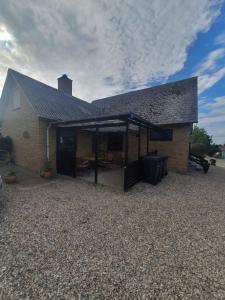 una casa con un gran patio con techo en Lovely Holiday Home With Views Of Fields, en Lebøl