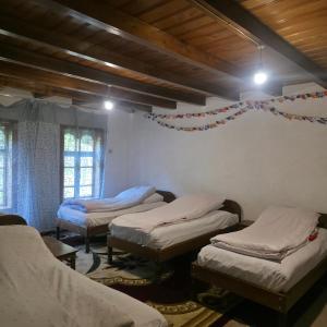 ein Zimmer mit drei Betten und einer Decke mit Lichtern in der Unterkunft Sim Guesthouse in Sım