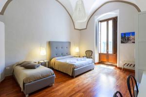 a bedroom with two beds and a large window at B&B Centro Storico Lecce in Lecce