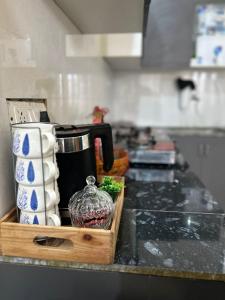 Eine Küchentheke mit einem Tablett mit Tassen und einer Kaffeekanne in der Unterkunft Rooftop Bliss in Panchkula