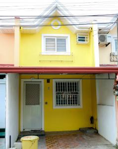 a yellow house with a window and a door at Clark Stays Yellow in Iba