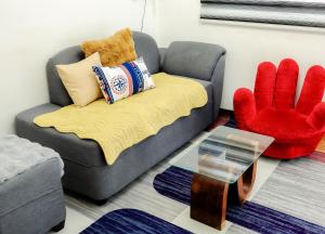 a living room with a gray couch and a red chair at Clark Stays Yellow in Iba