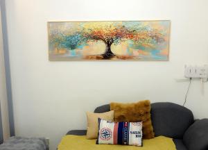 a teddy bear sitting on a couch under a painting at Clark Stays Yellow in Iba