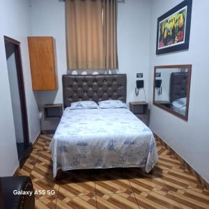 Anciejo inn ll في ليما: غرفة نوم بها سرير كبير ومرآة