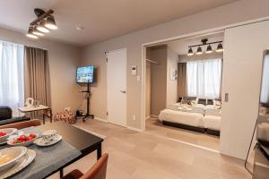 a bedroom and living room with a bed and a table at Mi-Hotel Kitashinjuku 北新宿 in Tokyo