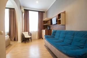 a living room with a blue couch in a room at Kinor David Glatt Kosher Hotel in Tbilisi City