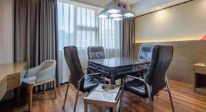 a room with a table and chairs in a room at Borrman Hotel Nanning Anji Passenger Station Xijin Metro Station in Nanning