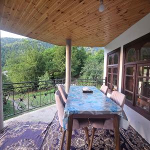 Ein Tisch und Stühle auf einem Balkon mit Aussicht in der Unterkunft Sim Guesthouse in Sım