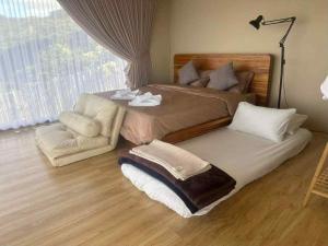 een slaapkamer met een groot bed en een stoel bij แล้วแต่เพื่อนวิลล่า in Ban Huai Khai