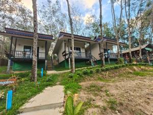 a house in the woods with a lot of trees at MookSkyDawBungalow in Trang