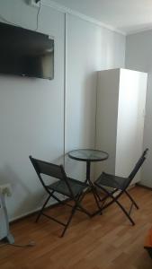 una mesa y 2 sillas en una habitación con TV en Hotel con C en Concepción
