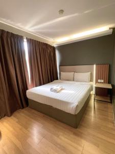 a bedroom with a large bed with white sheets at Hotel 99 Bandar Klang (Meru) in Klang