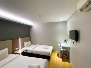Una habitación de hotel con dos camas, un escritorio y un televisor. en Hotel 99 Bandar Klang (Meru), en Klang 23 fotos más