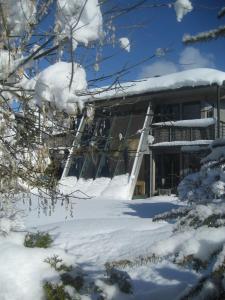 a building covered in snow with snow covered trees at Ferienhaus in Westendorf in Westendorf