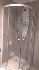 y baño con ducha y mampara de cristal. en Hotel con C, en Concepción
