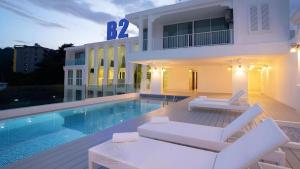a house with a swimming pool next to a building at B2 Phuket Premier Hotel in Ban Ket Ho