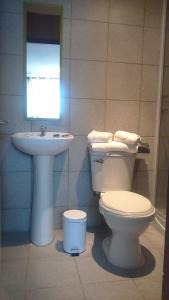 a bathroom with a toilet and a sink at Hotel con C in Concepción