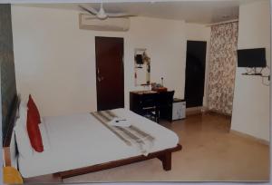 a room with a bed and a desk in it at Hotel Welfare Club in Bhilai