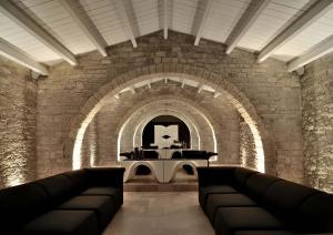 a large room with a stone wall and a clock on the wall at Masseria Torre Di Nebbia in Castel del Monte