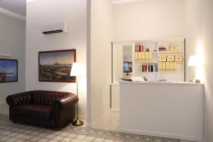 una sala de estar con una silla de cuero y una estantería de libros. en Dimora delle Arti, en Nápoles