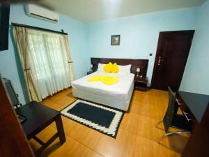 Premium City Guesthouse في غابورون: غرفة نوم عليها سرير ومخدة قطط