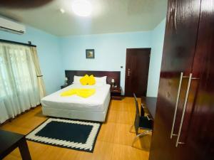 Premium City Guesthouse في غابورون: غرفة نوم بسرير ابيض مع مخدات صفراء