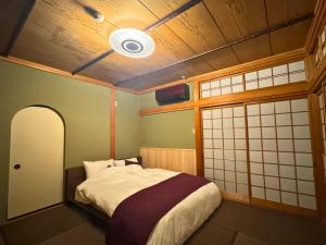 a bedroom with a bed in a room with a ceiling at 海の宿mare in Hakui