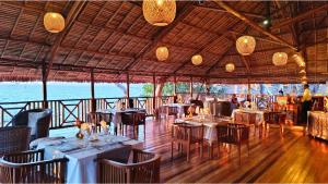 a restaurant with tables and chairs with a view of the ocean at Diana Lodge in Ankify