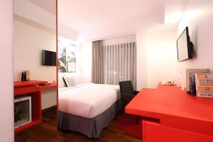 a hotel room with a bed and a red desk at The Silk at Dago Boutique Hotel in Bandung
