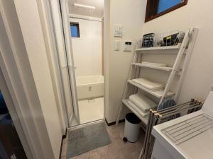 ein kleines Badezimmer mit Dusche und Handtuchhalter in der Unterkunft OSAKA DOSHIN HOUSE in Osaka + 46 Fotos
