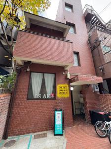 ein Backsteingebäude mit einem US-Air-Schild davor in der Unterkunft OSAKA DOSHIN HOUSE in Osaka