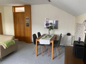 a living room with a dining room table and chairs at Ferienwohnung Falkensteinblick in Pfronten