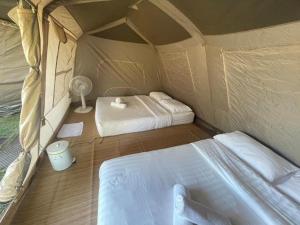 a room with two beds in a tent at Montana Cotswolds Resort in Ban Kom