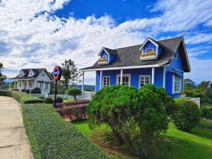 a blue house with a black roof at Montana Cotswolds Resort in Ban Kom