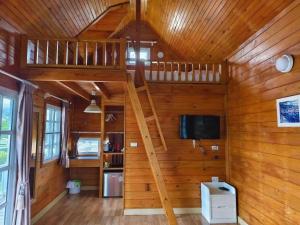 a living room with a staircase in a wooden house at Montana Cotswolds Resort in Ban Kom