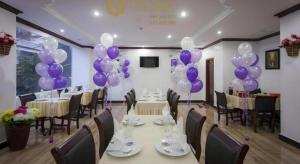 a banquet hall with purple balloons and tables and chairs at The Mou Hotel in Phnom Penh