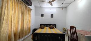 a room with a bed and a table and a ceiling at Anaaya Riverside Nest in Jāmb