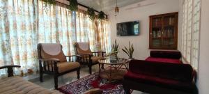 a living room with chairs and a couch and a table at Anaaya Riverside Nest in Jāmb