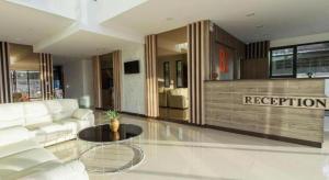 ein Wohnzimmer mit einer weißen Couch und einem Tisch in der Unterkunft B2 Ubon Premier Hotel in Ban Nong Bua