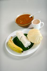 a plate of food with a banana and dip at Ayurnest Pool Resort Wayanad in Batheri