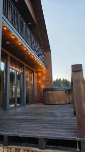 ein Gebäude mit einem Holzdeck mit einer Bank darauf in der Unterkunft Спас Резорт in Spas