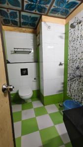 a bathroom with a toilet and green and white checkered floor at Hotel Gokul Plaza Near Railway Station Bhubaneswar in Bhubaneshwar