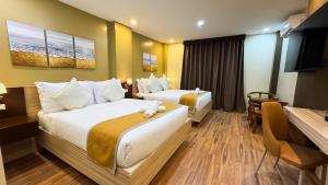 a hotel room with two beds and a table at Hollywood Hotel Palawan in Puerto Princesa City