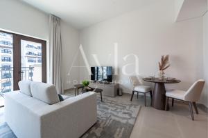 Una sala de estar con un sofá blanco y una mesa. en The Yas Coast Studio on Yas island by Ayla, en Yas Island