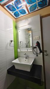 a bathroom with a sink and a mirror at Hotel Gokul Plaza Near Railway Station Bhubaneswar in Bhubaneshwar